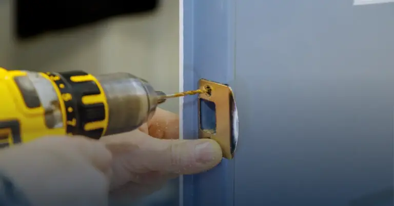 Técnico instalando una cerradura nueva en la puerta de una casa
